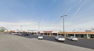 Google Maps view of one-story shopping center with large parking lot.