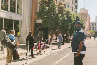 People walking and biking on protected bike lane in Tenderloin District, San Francisco.