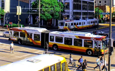 Buses and pedestrians on busy Baltimore street.