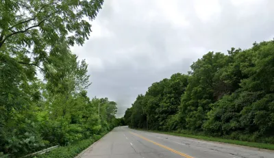 Google Street View of wide roadway flanked by green trees in Milwaukee, Wisconsin.