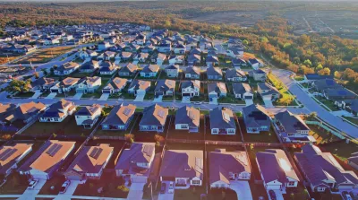 Aerial view of single-family homes with rooftop solar panels in planned development near Austin, Texas.