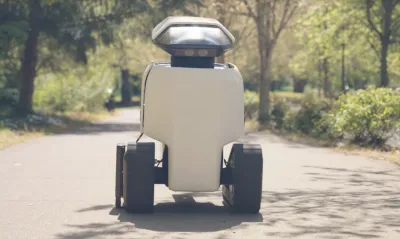 White robot drivign down sidewalk in Irvine, California.