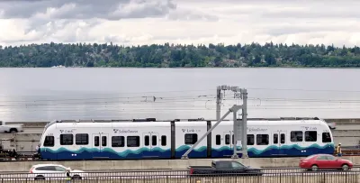 White and blue Sound Transit light rail train on floating brige.