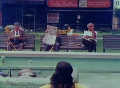 Screenshot of men sitting on bench outside in city in The Social Life of Small Urban Spaces.