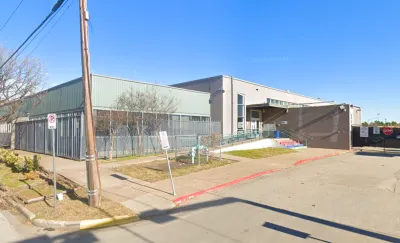 Street view of one-story commercial building with few windows  in Houston, Texas.