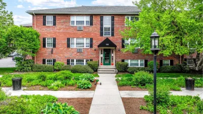 Red brick three-story garden apartment building in Newton, Massachusetts.