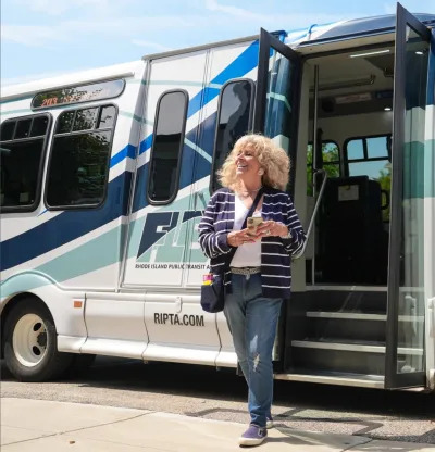 Blonde woman exiting Rhode Island on-demand microtransit bus.