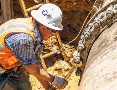 A worker fixes a large pipe