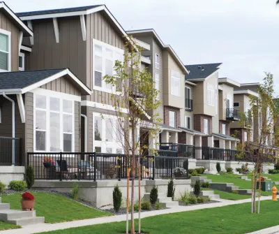 Small two-story multifamily homes next to each other with small green lawns in front in Spokane, Washington.