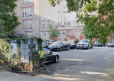 A parking lot between buildings in New York City with signs for NYPD vehicles only.