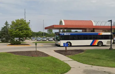 White bus with blue stripes at transit station in Madison, Wisconsin.