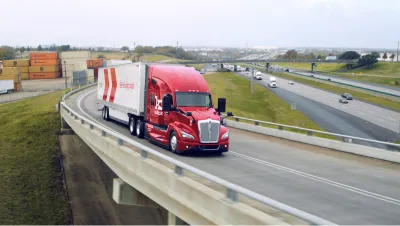 A red semi truck on a highway onramp