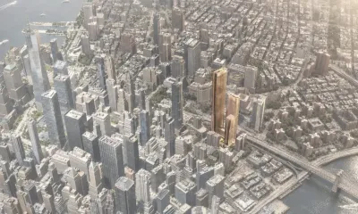 A rendering of the proposed building, which is tall and highlighted in yellow to stand out from the surrounding buildings.