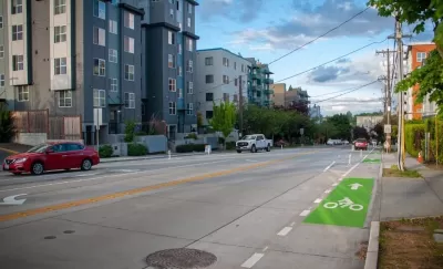 Green painted bike lane on street next to modern mid-rise apartment buildings in Seattle, Washington.