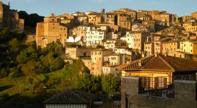 The city of Siena in Italy, located on a hillside and bathed in Tuscan sunlight.