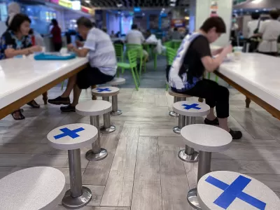 A restaurant in Singapore places tape on seats to maintain distance between diners during the Covid-19 pandemic in 2020.