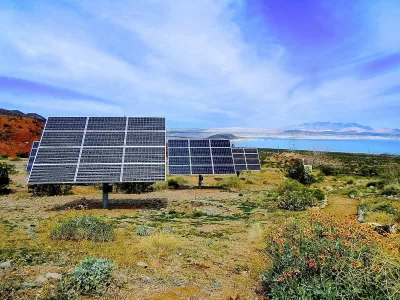 Solar panels installed ona hillside with Lake Mead, Nevada in background.