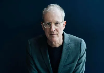 Headshot of Jeff Speck in grey suit against dark backdrop.