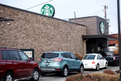 A line of cars wait at the drive-thru window of a starbucks.