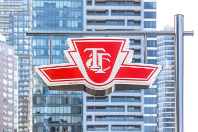 The TTC logo is visible on a sign with the high-rises of Toronto in the background.