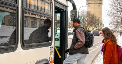 Man and woman boarding bus on winter day in Ann Arbor, Michigan.