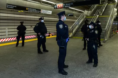 A group of police officers wearing masks during the Covid-19 pandemic gather on a subway platform in New York City.