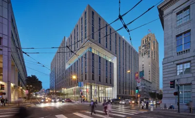 Modern multistory residential building, part of UC Law school in downtown San Francisco at dusk.