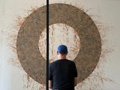 Photo of man looking at large painting.