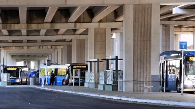  CapMetro buses parked at Westgate Transit Center under freeway overpass in Austin, Texas.