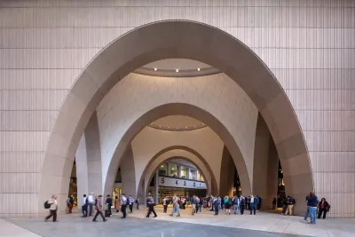 Large arched doorway at entrance to Boston's South Station train station after 2025 renovation with crowd of people walking around at bottom.