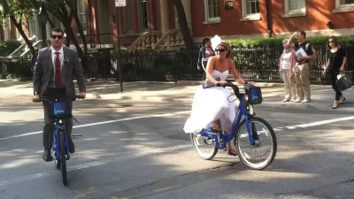 A bride and groom riding on citi bikes in New York