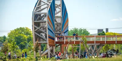Large wood structure with bridge and people standing on it in green park in Toledo, Ohio.