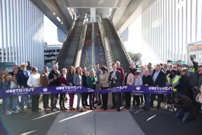 Group of officials cutting purple ribbon.
