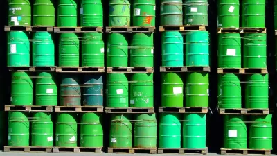 pallets of green oil barrels stacked