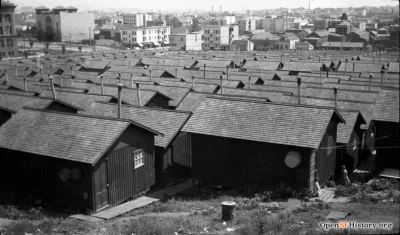 Black and white photo of refugee camp of small wood cottages in Dolores Park, San Francisco CA after 1906 earthquake.