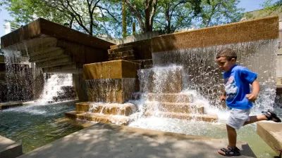 child playing in Peavey Plaza fountain in Minneapolis