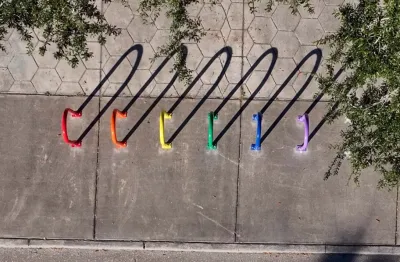6 bike racks, shot from above, each painted a color of the Pride rainbow