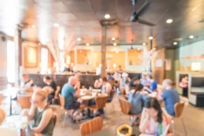 Blurred photo of crowded, brightly lit restaurant