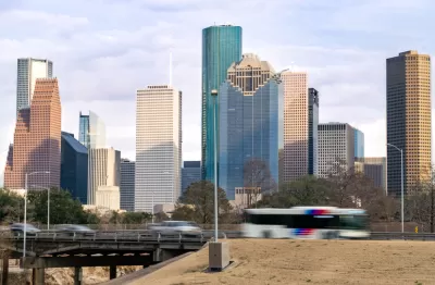 View of Houston freeway with bus, cars, and downtown skyline in background