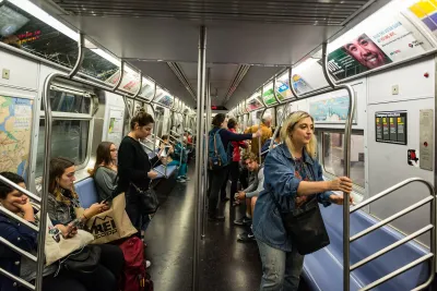 People sitting and standing on a New York Coty subway train.