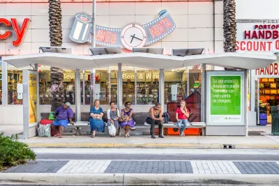 People waiting at a covered bus stop in Miami, Florida.