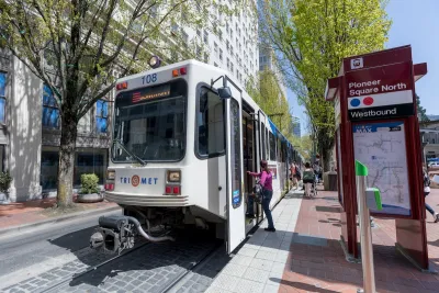Passenger boarding white streetcar in Portland, Oregon.