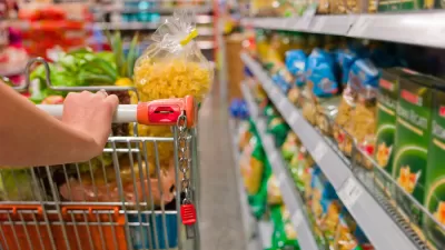 hand pushing a cart down a supermarket aisle