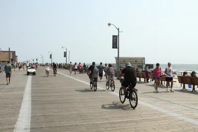 People riding bikes and walking on boardwalk in Long Beach, New York.
