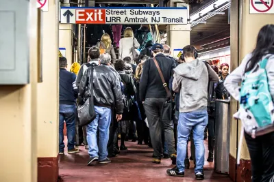 Crowded NYC subway station with signs for Long Island Railroad and NJ Transit.