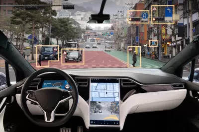 View from inside driver's seat of car with autonomous technology, with yellow rectangles highlighting obstacles in road