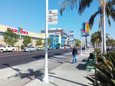 Sidewalk bus stop with bench and no shade in Los Angeles, California