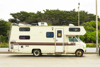 Small recreational vehicle parked on city street.