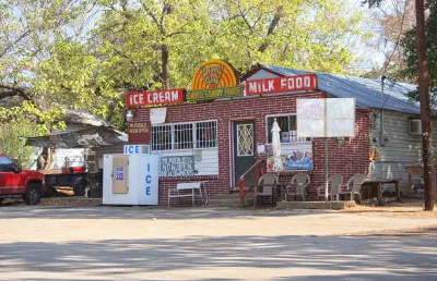 Small brick food store with vintage signs and new handwritten signs for Mi Pueblo food store.