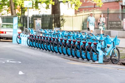 Row of blue New Orleans bike share bikes at a docked station on street